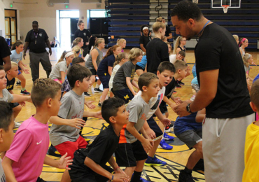 Coaches helping basketball campers work on defense skills